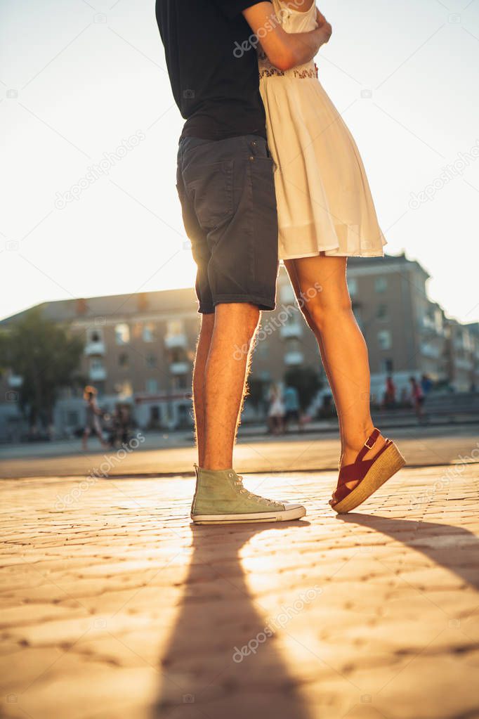 legs guy and the girl embracing on a background of city