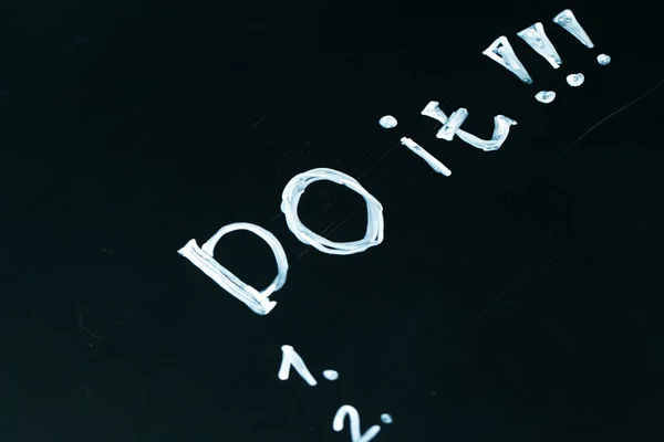 Inscription do it list drawn with chalk on a school blackboard dark — Stock Photo, Image