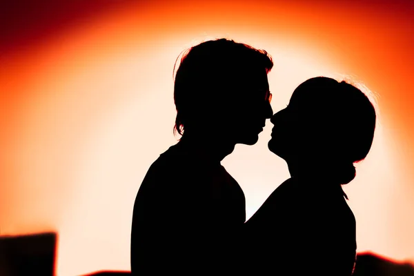 Silhouetten von Mann und Mädchen, die auf einem Hintergrund die Stadt umarmen — Stockfoto