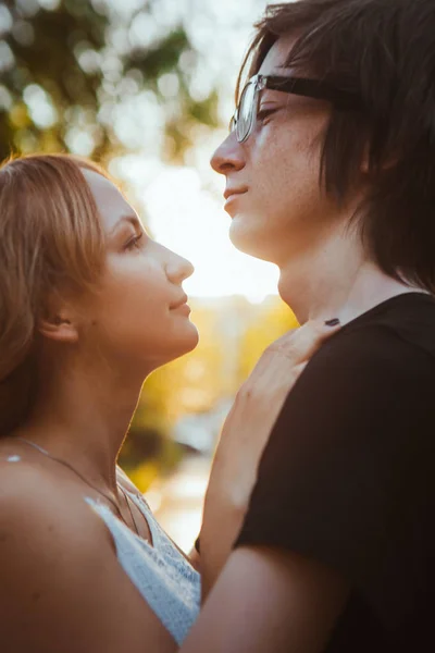 Mann und Mädchen umarmen sich vor dem Hintergrund eines Parks — Stockfoto