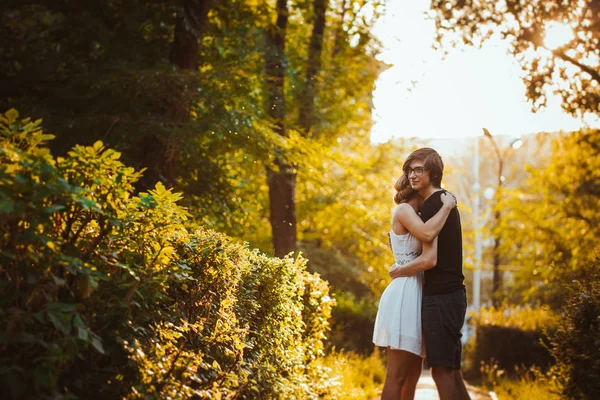 Jongen en het meisje omarmen op een achtergrond van park — Stockfoto