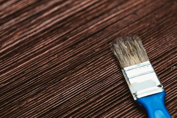 brush to paint on a dark wooden background