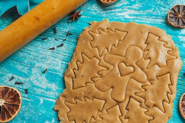 Zencefilli kurabiye hamuru ile tarçın mavi ahşap masa üzerinde pişirme için kalıplar