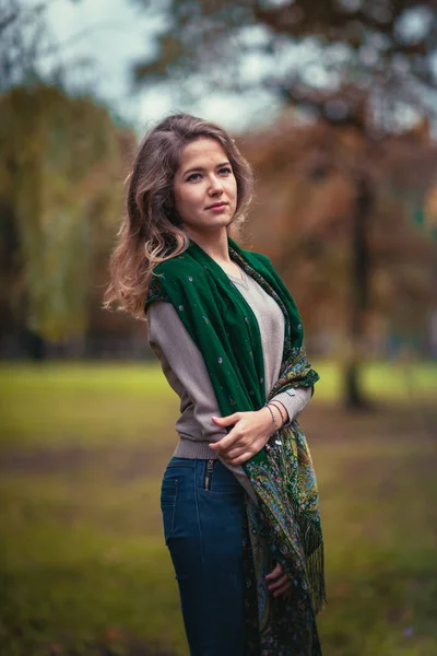 Retrato de uma jovem com cachecol verde no parque de outono de fundo — Fotografia de Stock