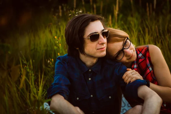 Jongen en het meisje zittend in het gras — Stockfoto
