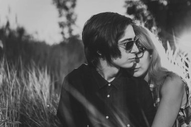 siyah ve beyaz adam çim günbatımı bir arka plan üzerinde oturan kız