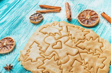 Zencefilli kurabiye hamuru ile tarçın mavi ahşap masa üzerinde pişirme için kalıplar