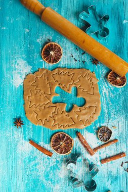 Zencefilli kurabiye hamuru ile tarçın mavi ahşap masa üzerinde pişirme için kalıplar