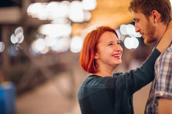 Gelukkige paar omarmen in de avond op een lichte slingers — Stockfoto