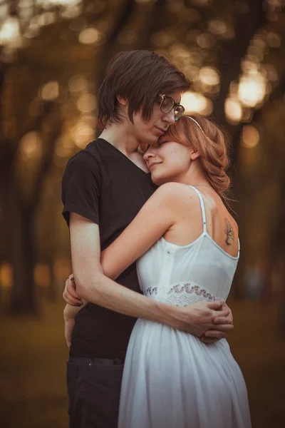 Jongen en het meisje op een achtergrond van natuurpark omarmen — Stockfoto