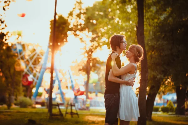 Jongen en het meisje knuffelen bij amusement achtergrond — Stockfoto