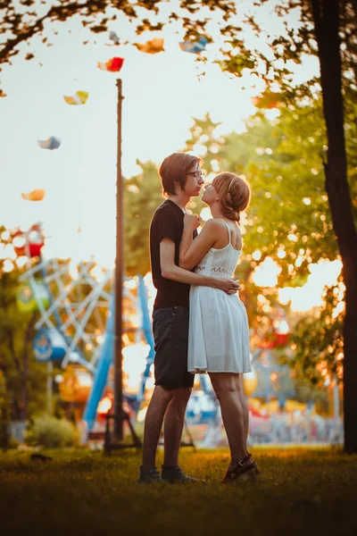 Kerl und das Mädchen umarmen sich vor Vergnügungshintergrund — Stockfoto