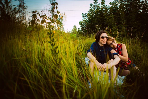 Killen och tjejen sitter i gräset — Stockfoto
