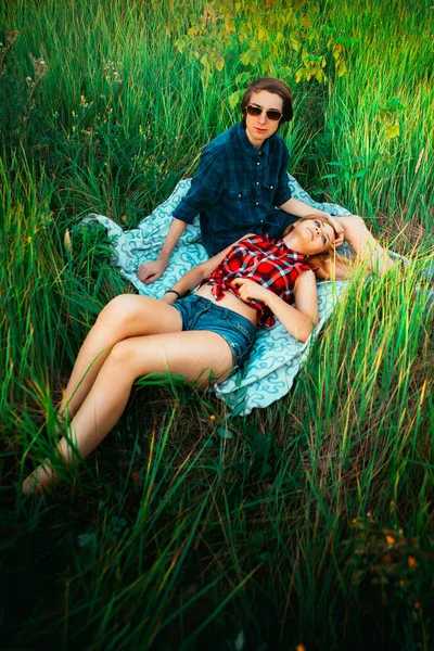 Facet i dziewczyna siedzi w trawie — Zdjęcie stockowe