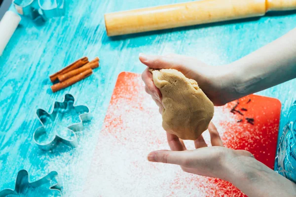 Girl rolls the dough on the red board to blue wooden table — Stock Photo, Image