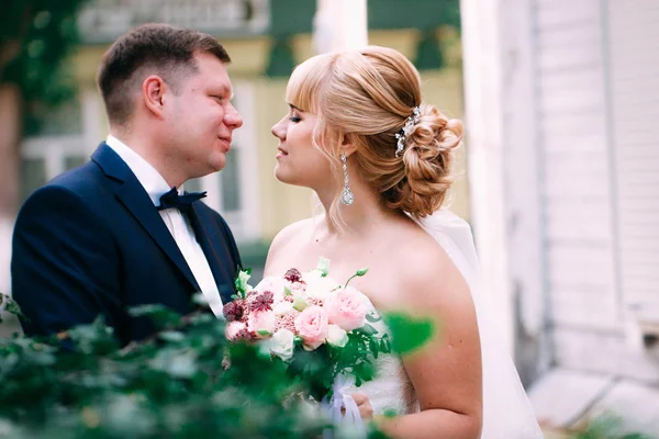 Menyasszony és a vőlegény, a háttérben a kert kerítés — Stock Fotó