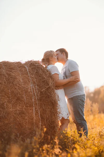 Storia d'amore uomo e donna sullo sfondo di pagliai sole — Foto Stock