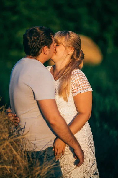 История любви мужчина и женщина на фоне стога сена солнце — стоковое фото