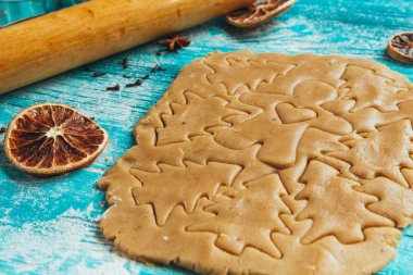 Zencefilli kurabiye hamuru ile tarçın mavi ahşap masa üzerinde pişirme için kalıplar