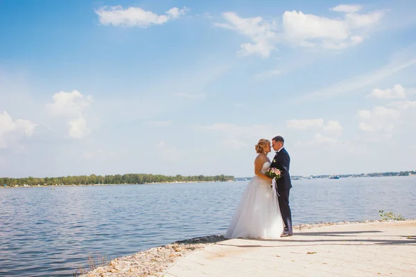 Bride and groom on the background of the river — Stock Photo, Image