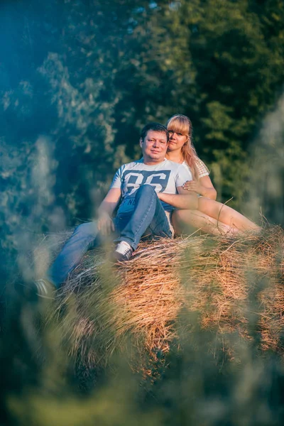 Storia d'amore uomo e donna sullo sfondo di pagliai sole — Foto Stock