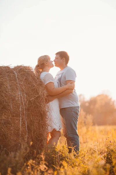 Love story man and woman on the background of haystacks  sun — Stock Photo, Image