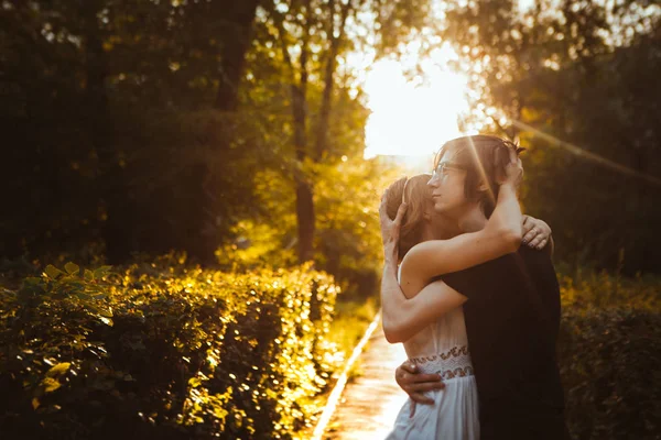 Férfi és a lány ölelkezik a háttérben a park — Stock Fotó