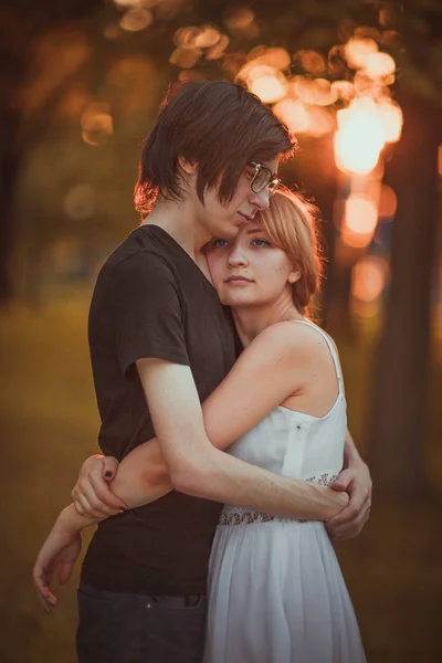 Chlap a dívka objímá na pozadí přírodního parku — Stock fotografie