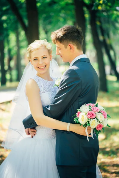 Portré a menyasszony és a vőlegény, a háttérben a park sikátor — Stock Fotó