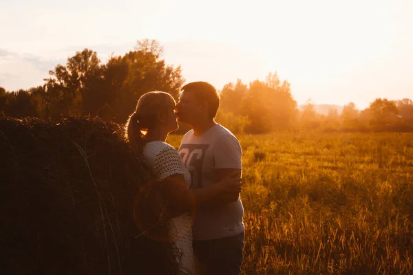 Love story man och kvinna på bakgrunden av höstackar solen — Stockfoto