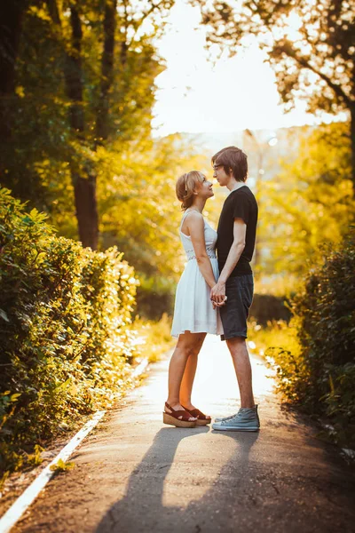 Kille och flicka omfamna på en bakgrund av park — Stockfoto