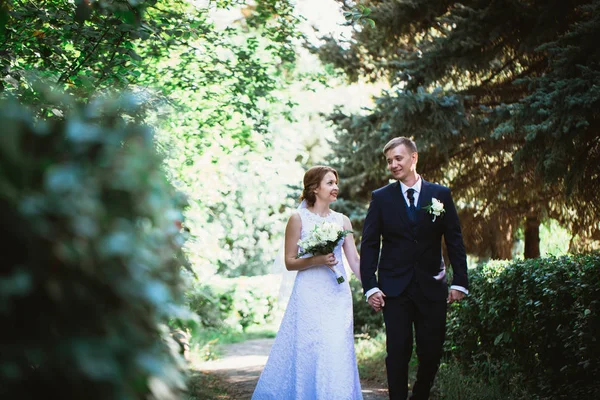 Couple mariée et marié sur un fond de parc — Photo