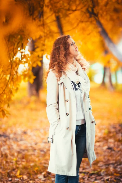 Young girl in a light coat on the background of autumn park — Stock Photo, Image