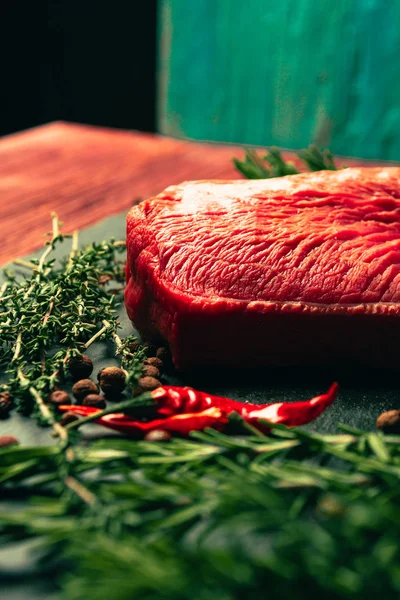 Carne de res cruda con especias en pizarra tablero de cocina de piedra — Foto de Stock