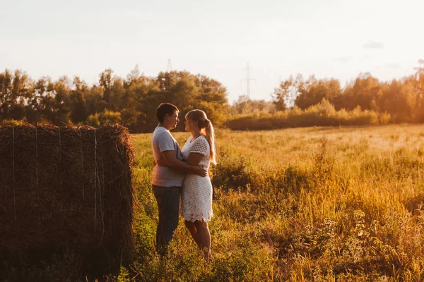 Love story man och kvinna på bakgrunden av höstackar solen — Stockfoto