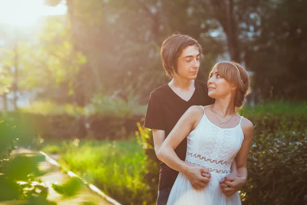 Kille och flicka omfamna på en bakgrund av park — Stockfoto