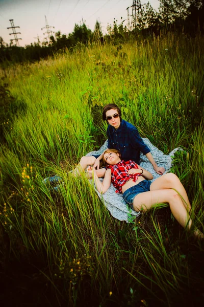 Le gars et la fille assis dans l'herbe — Photo