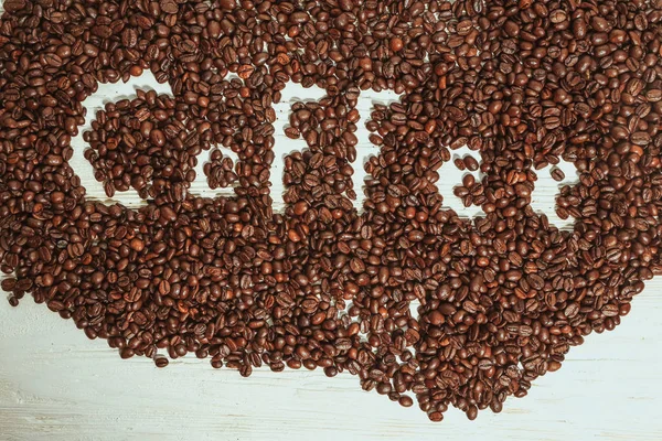 The words coffee written against scattered natural coffee — Stock Photo, Image