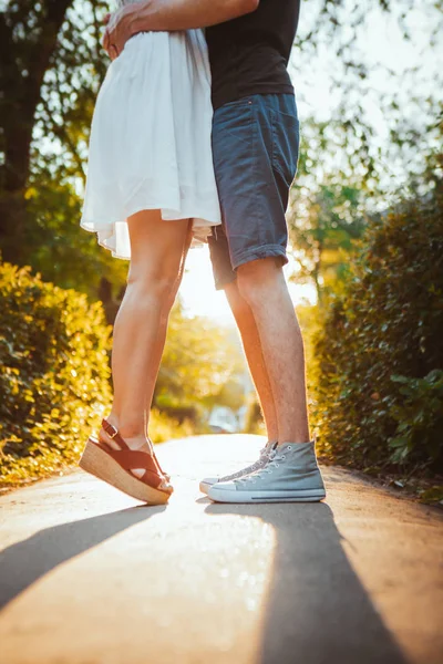 Парень с ногами и девушка, обнимающиеся на фоне парка — стоковое фото