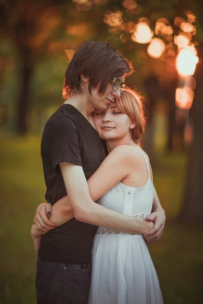 Killen och tjejen embracing på en bakgrund av naturpark — Stockfoto