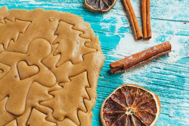 Zencefilli kurabiye hamuru ile tarçın mavi ahşap masa üzerinde pişirme için kalıplar