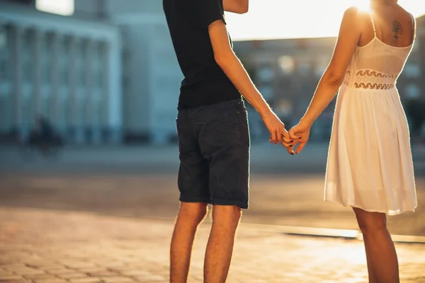 Piernas chico y la chica abrazando en un fondo de la ciudad — Foto de Stock