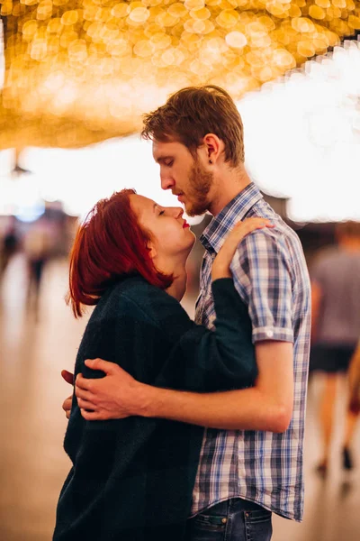对幸福的夫妇拥抱、 亲吻的晚上上光的花环 — 图库照片