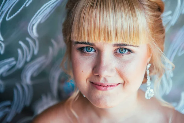 Portrait of young beautiful happy bride near the window — Stock Photo, Image