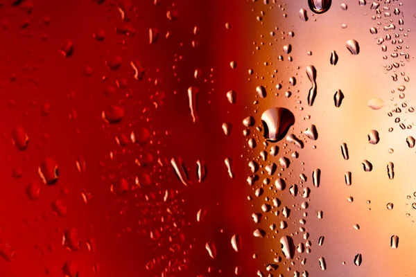 Droppar på glas regn röd bakgrund — Stockfoto