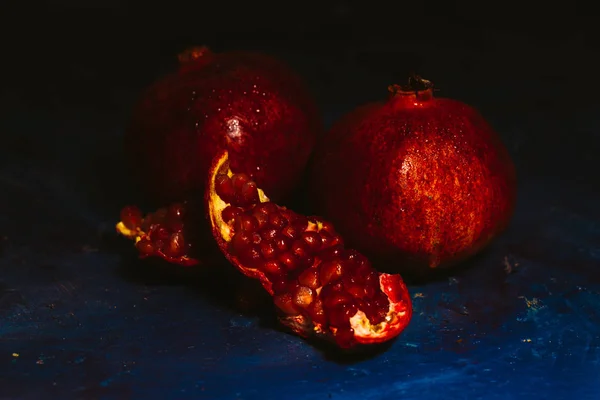 Red sliced pomegranate on a blue abstraction background — Stock Photo, Image