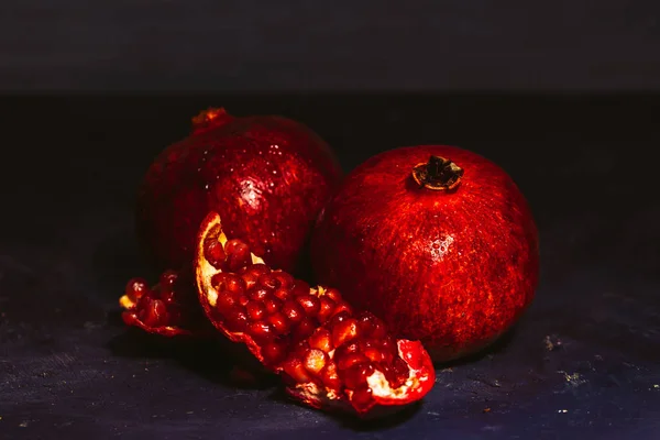 Red sliced pomegranate on a blue abstraction background — Stock Photo, Image