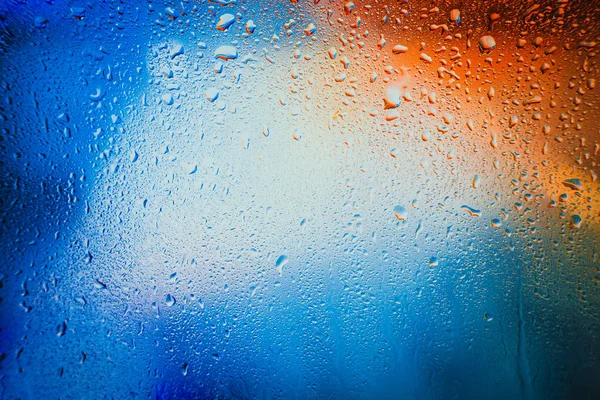 Gotas de chuva em um fundo multicolorido borrado — Fotografia de Stock