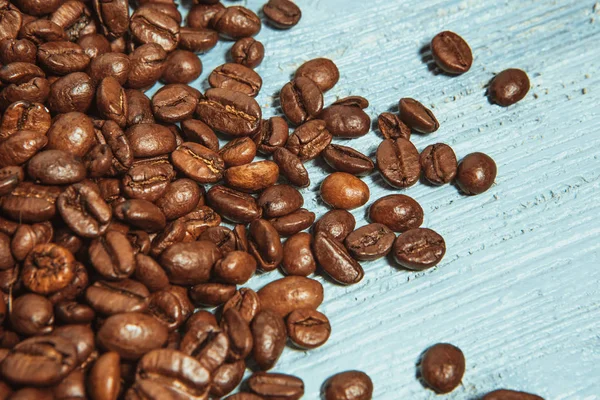 Dark many roasted coffee beans on blue background — Stock Photo, Image