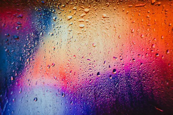 Gotas de chuva em um fundo multicolorido borrado — Fotografia de Stock